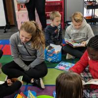 Central Woodlands lead a reading circle with kindergartners